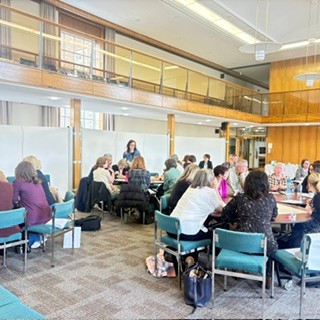 image of people sitting at tables in a large room